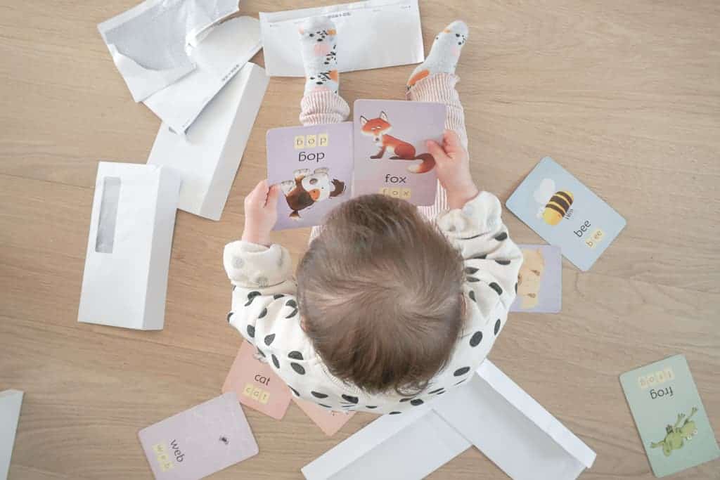 Signed Samantha's Easy and Free Toddler Activities includes putting flash cards into envelopes like what is picture here. Her daughter has a ton of envelopes and flash cards all around her while she stares at her two flash cards
