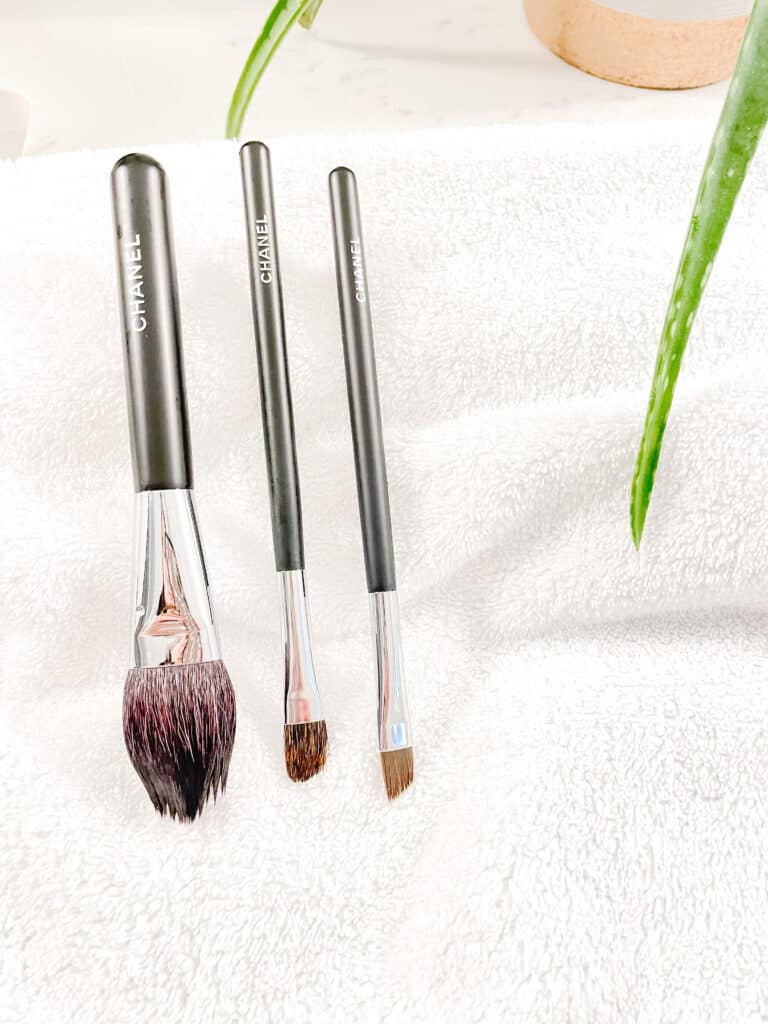 Signed Samantha talking about things you need to clean and that includes make up brushes which are pictured drying on a white towel