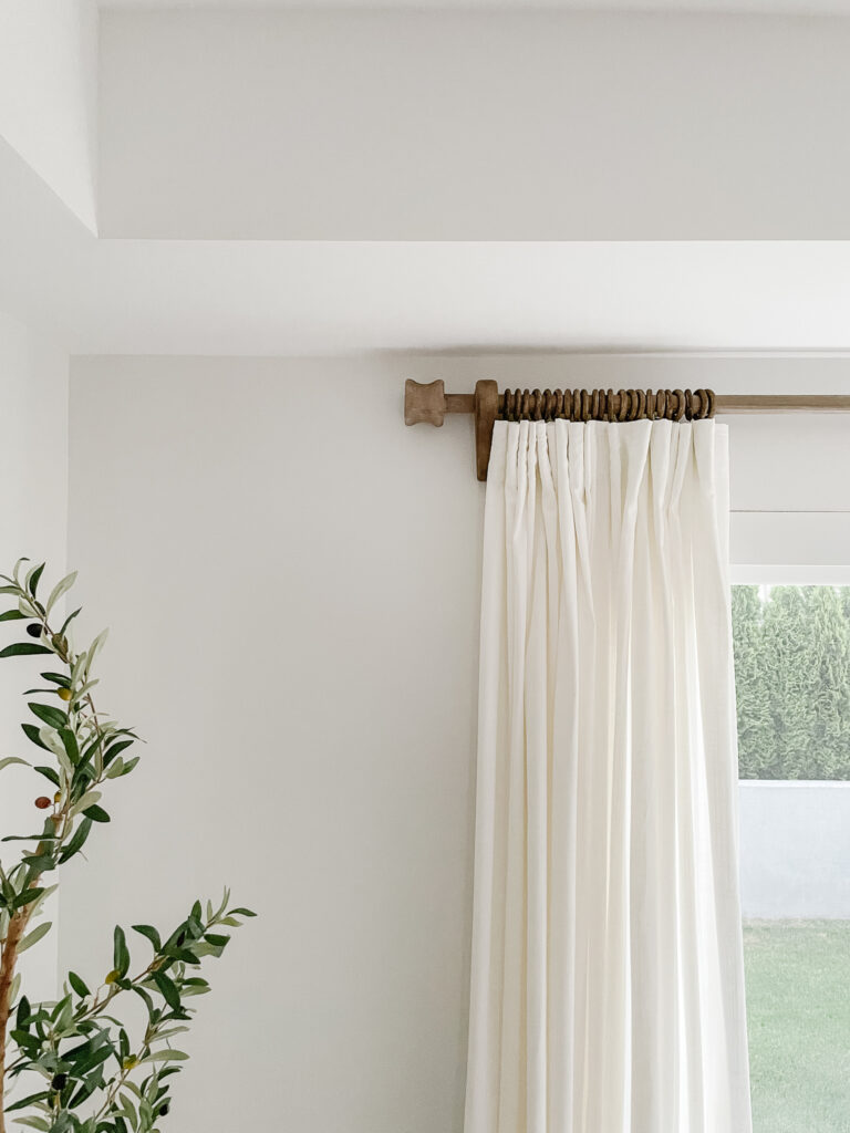 Signed Samantha's window treatment which includes a DIY rustic wooden curtain rod, DIY wooden curtain rings, and white curtians