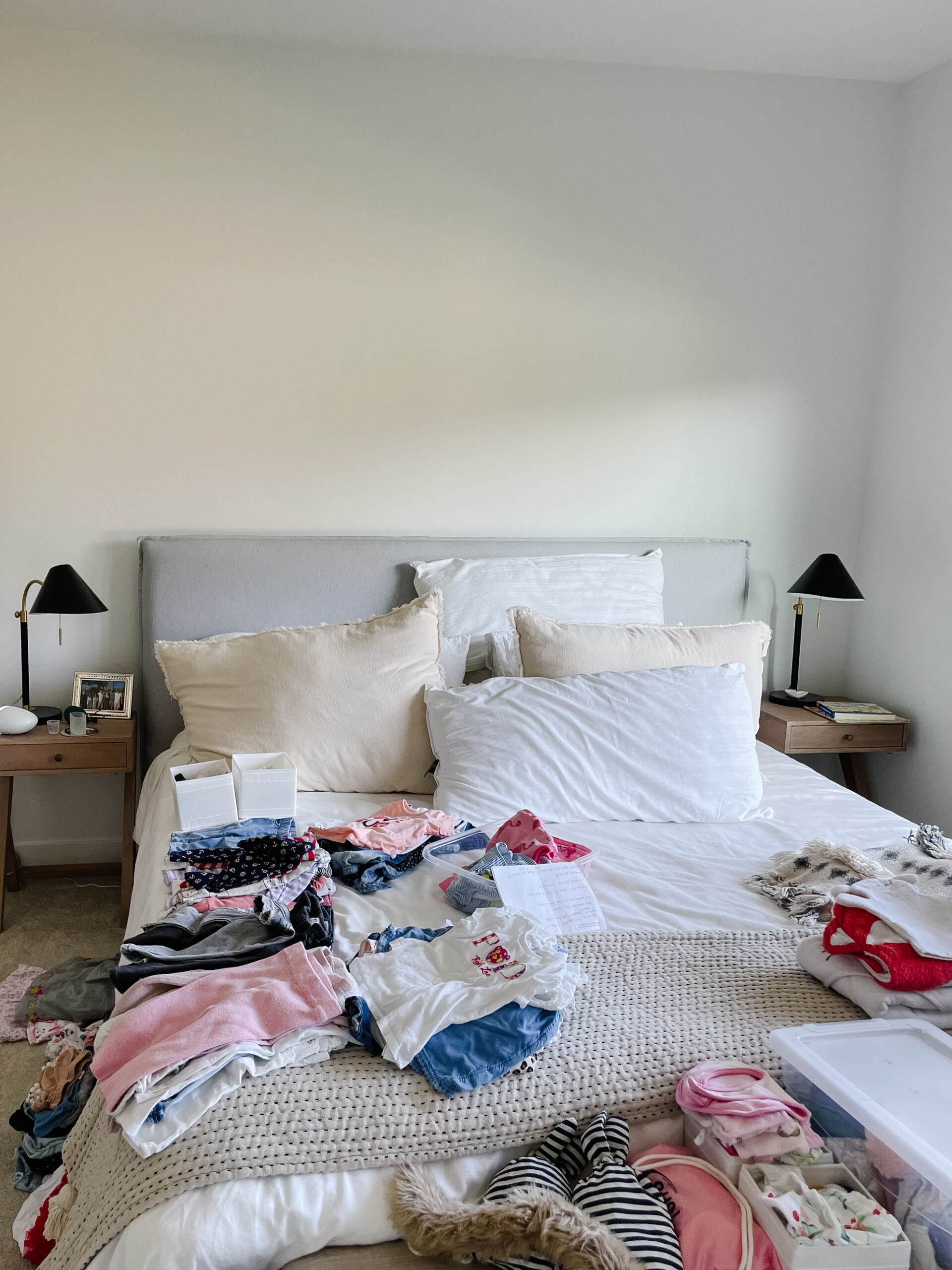 location of home office 2.0 - a picture of a bed with a bunch of kids clothes on it