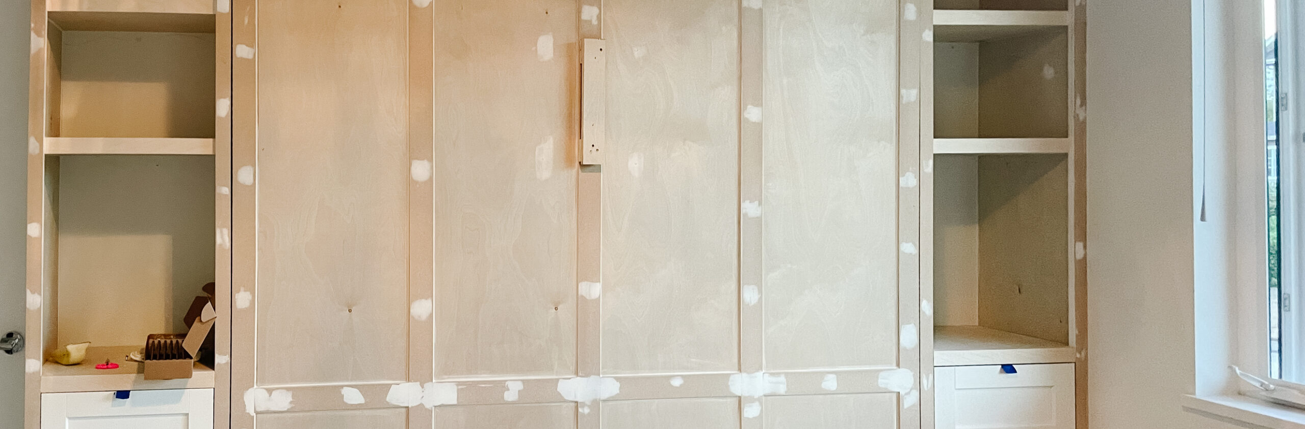 murphy bed built-in is complete with shelves, drawers, cabinets, complete with moulding. yet to be painted.