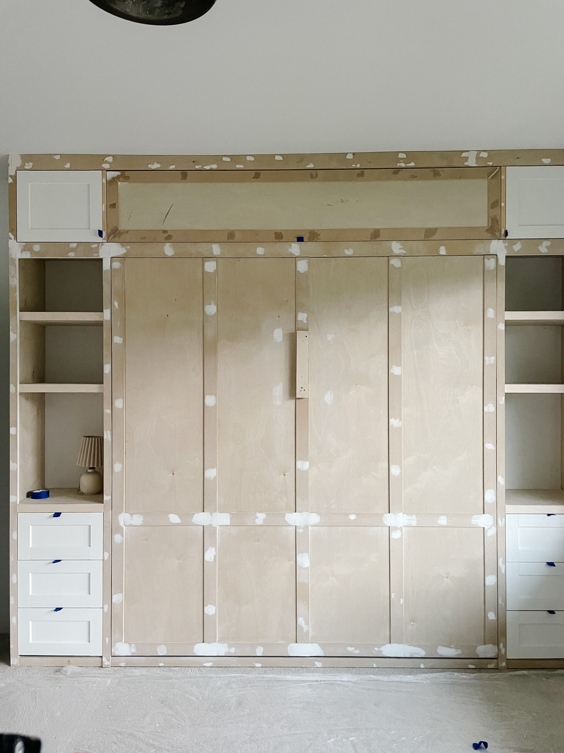 murphy bed built-in is complete with shelves, drawers, cabinets, complete with moulding. yet to be painted.