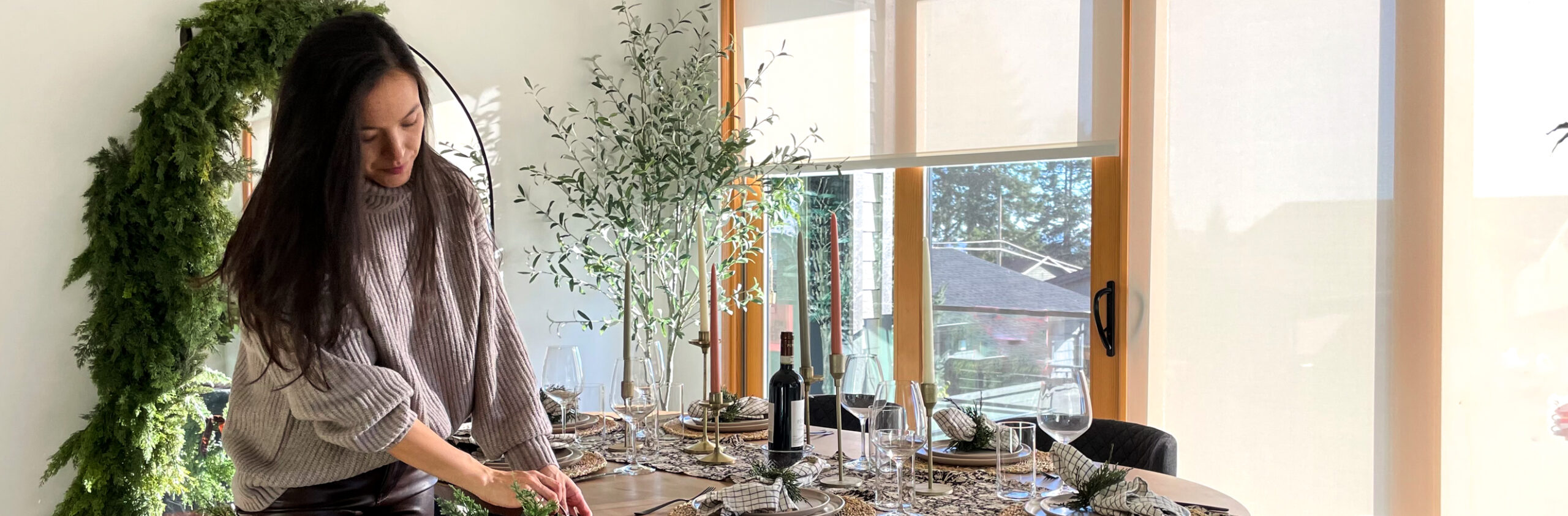 women dressed in holiday outfit setting the table. brown sweater and brown leather pants