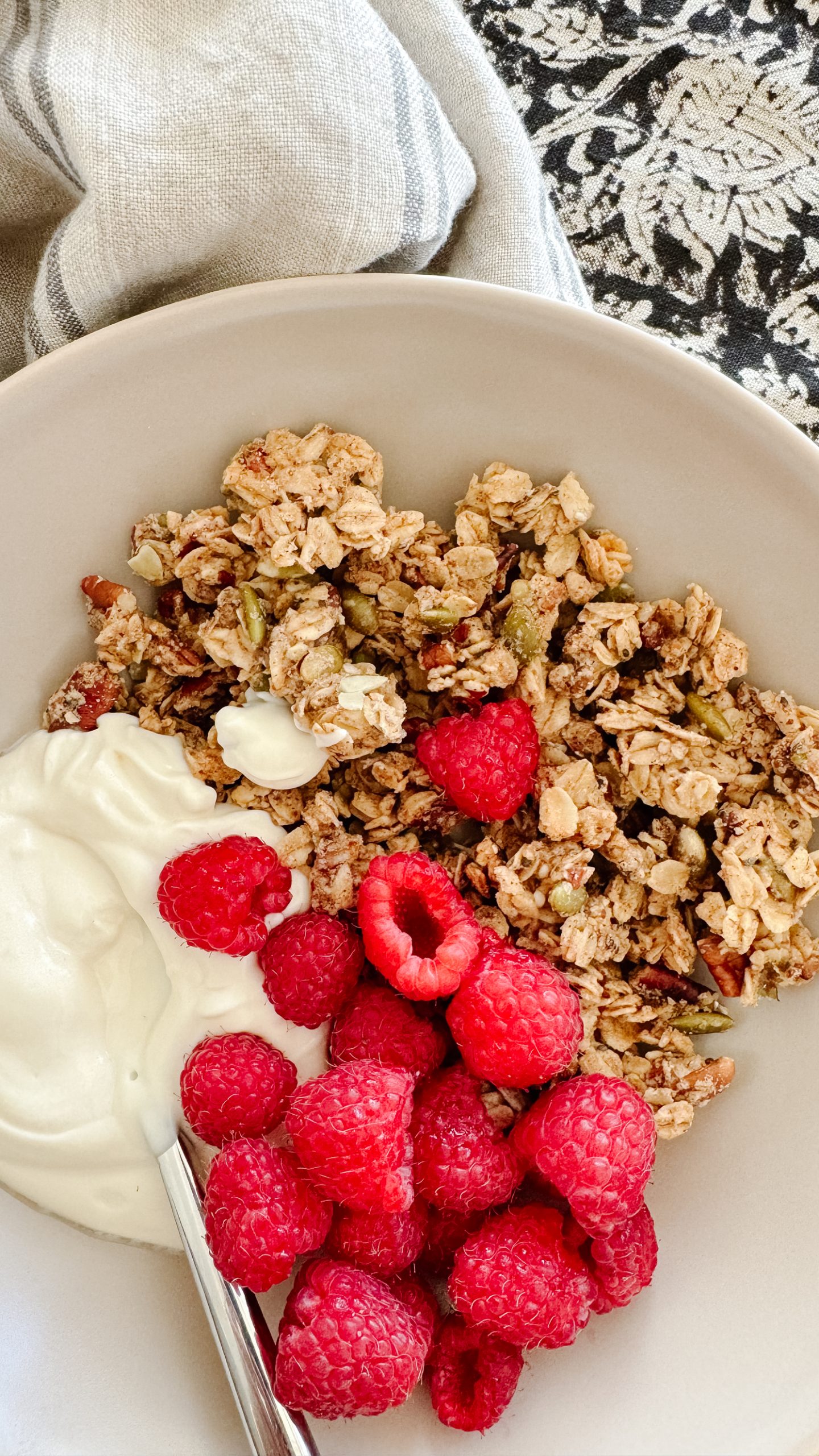 gluten-free granola in a bowl with raspberries and yogurt