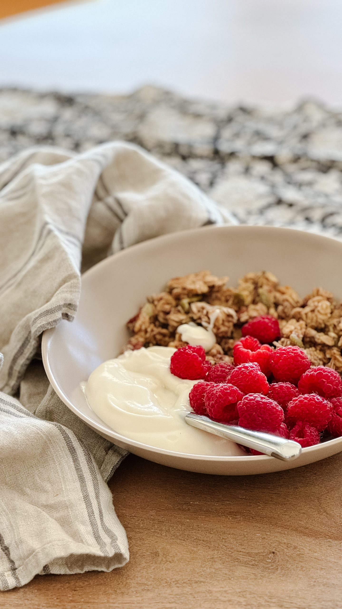 gluten-free granola in a bowl with raspberries and yogurt