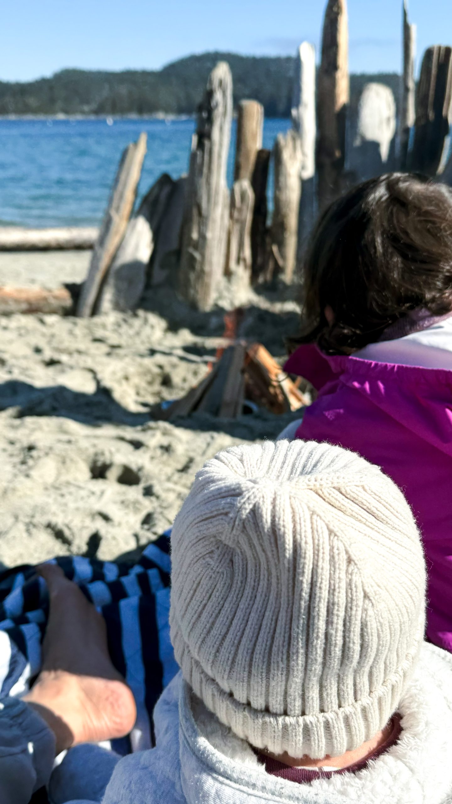 two kids sitting on a beach while a mother talks about returning to work