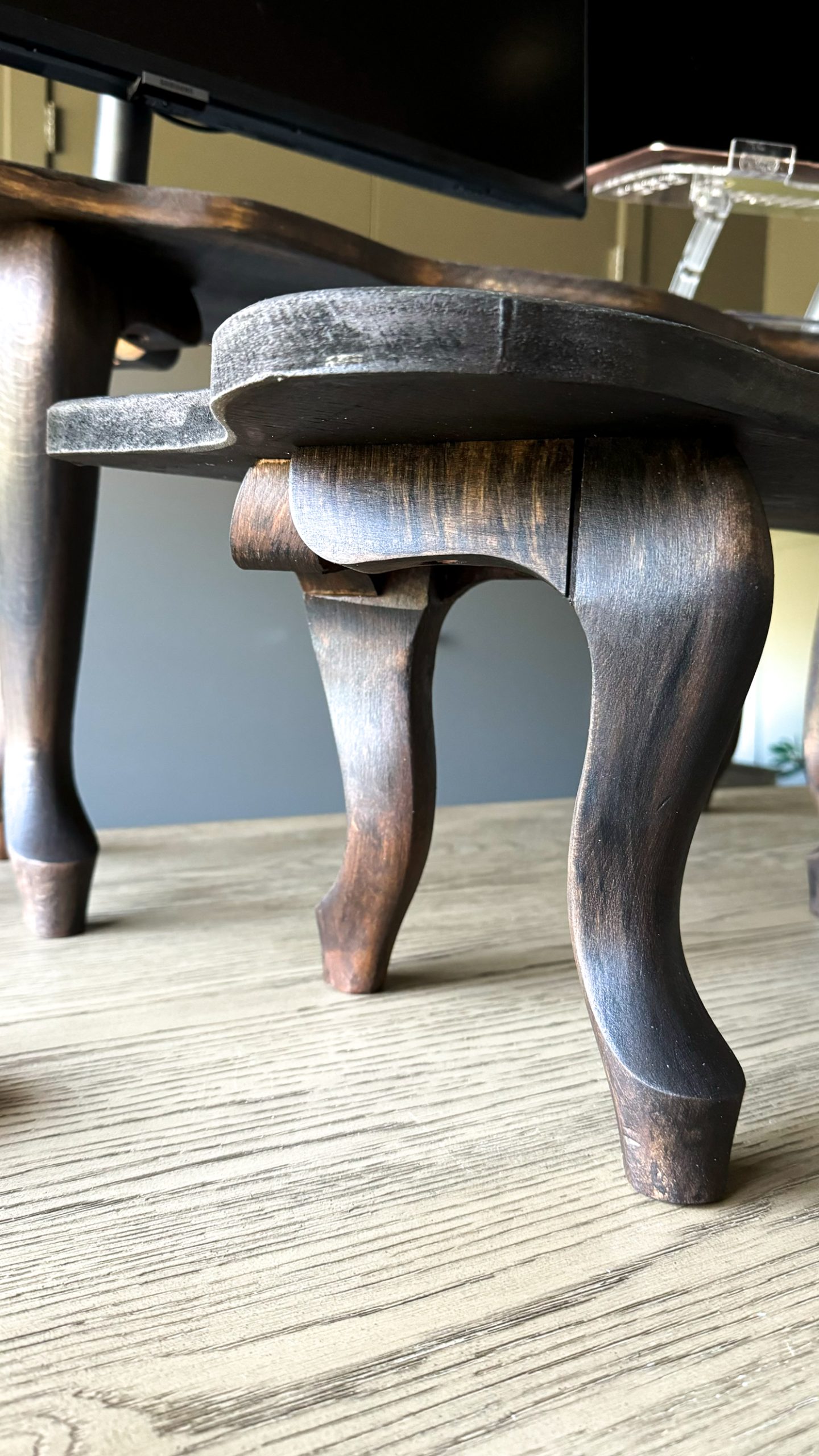 Desk riser up close on a desk with curved legs