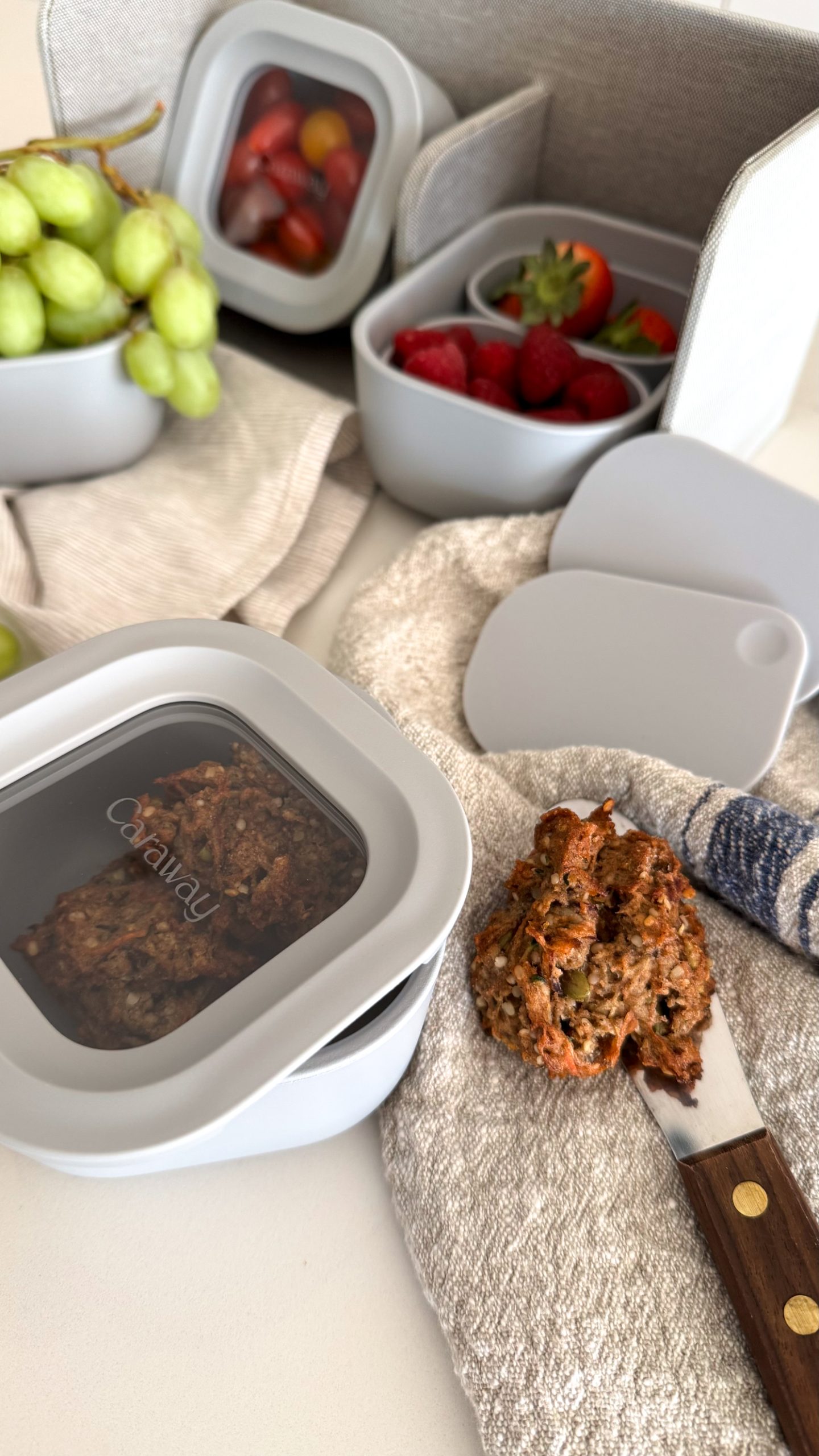Caraway's mini's picture on the table - their mini storage containers filled with fruits and cookies