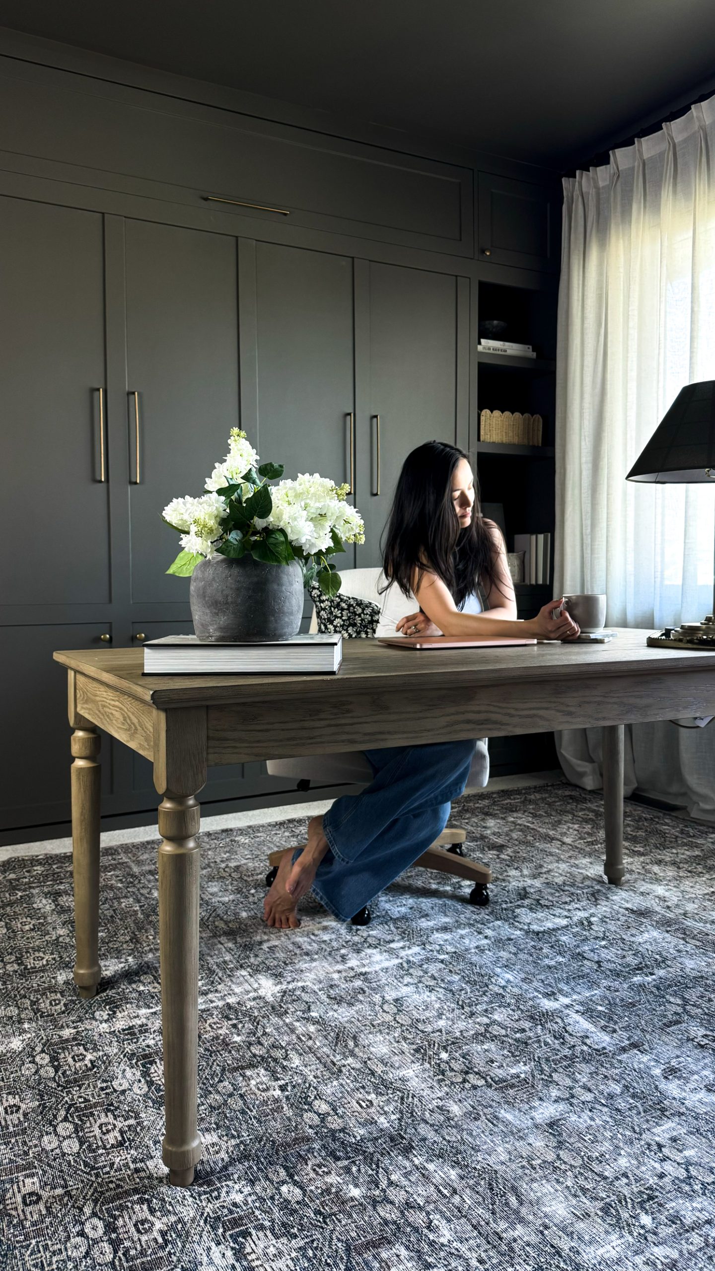 girl sitting at a desk in the middle of a home office