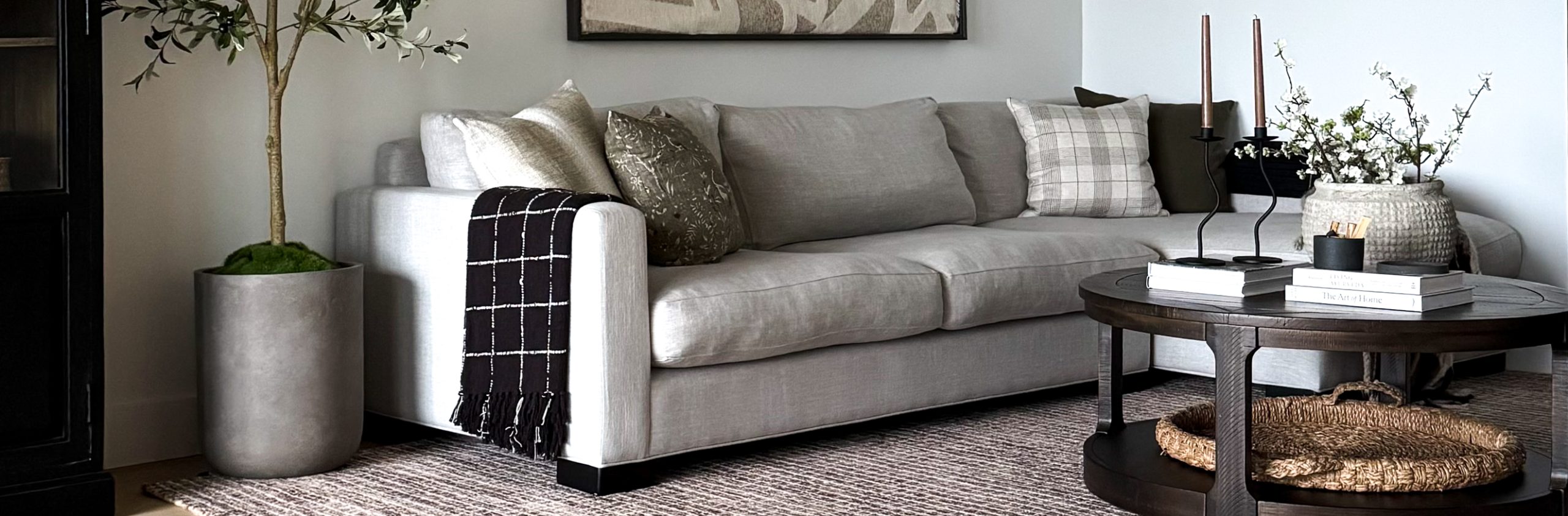 Making your room look bigger with the proper sized rug like in this living room with a big rug, nice sized coffee table, and sofa.